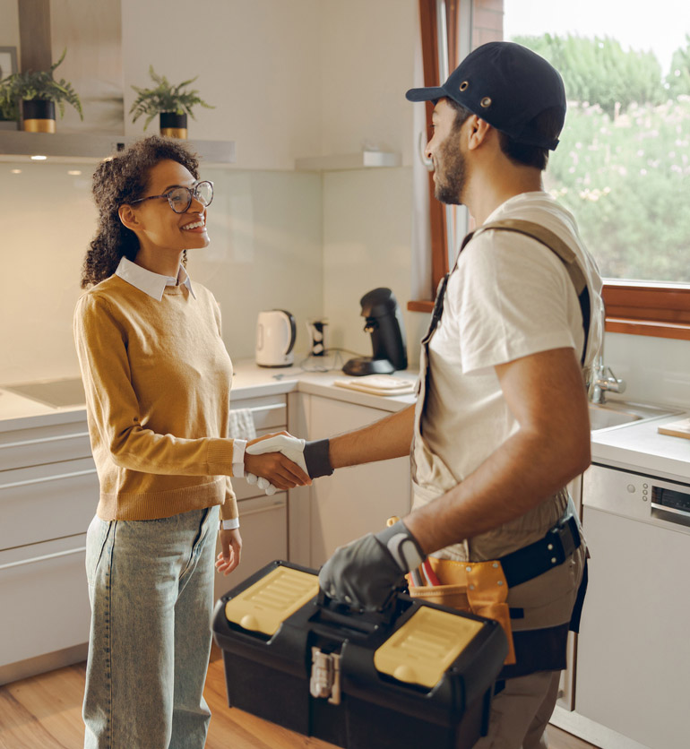 Smiling Long Island homeowner shaking hands with a Domino Fuel HVAC technician